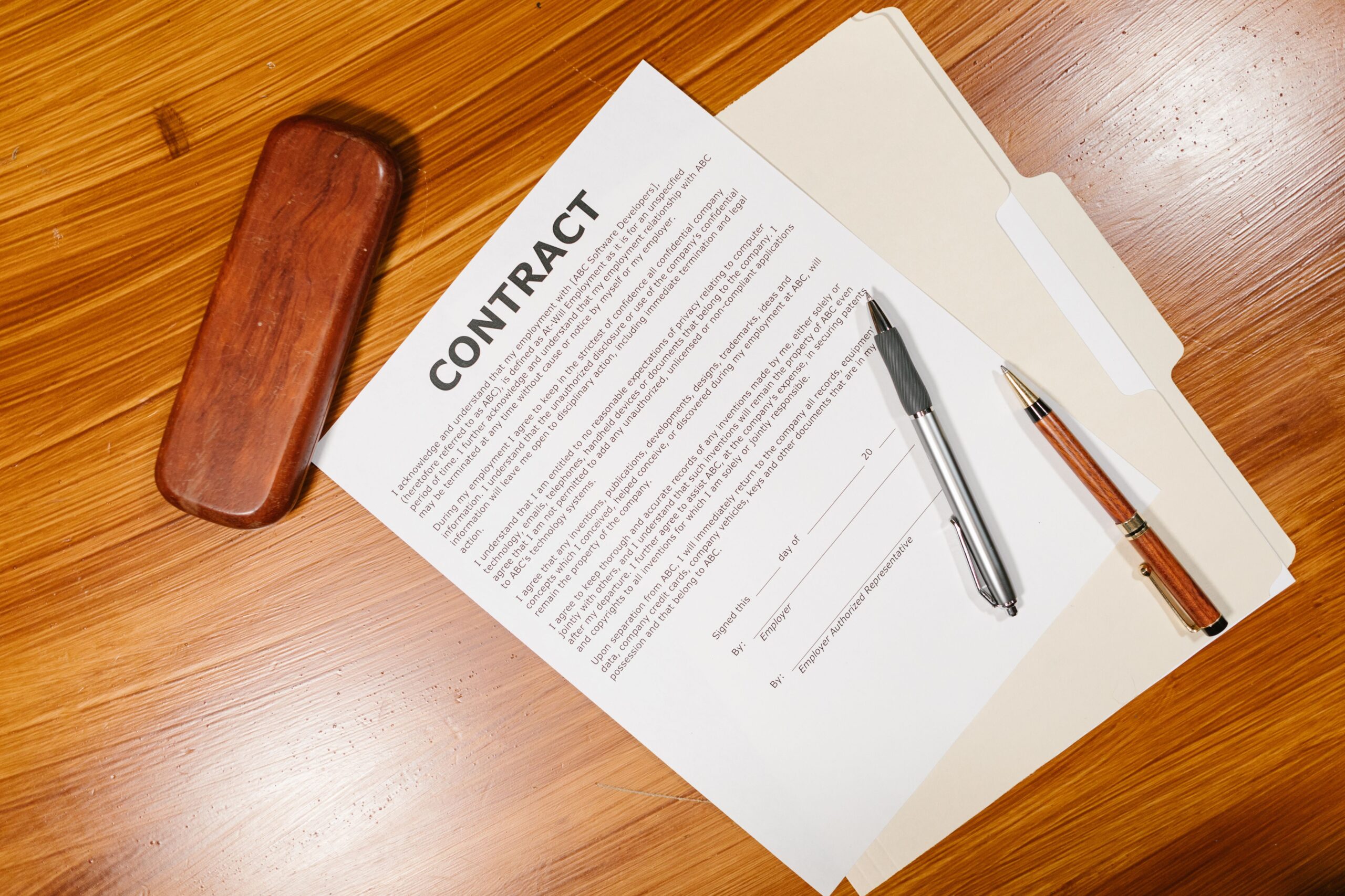 Documento de contrato com canetas, representando a Carteira de Trabalho e Previdência Social