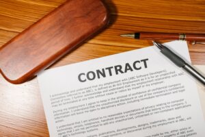 Contrato e caneta sobre mesa de madeira, representando documentos do contribuinte individual